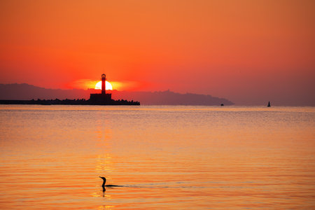 Seascape of sunrise over sea lighthouse and coastal beach shore, Varna, Bulgariaの写真素材