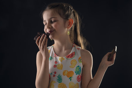 Chocolate and pretty hungry little woman portrait. Beautiful girl ready to eat chocolate bar.の写真素材