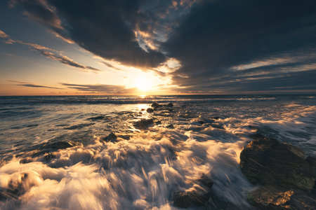 Golden splashing waves and sunrise seaの写真素材