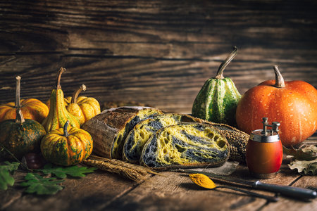 Homemade crusty sourdough bread oven baked made with wheat, activated carbon, pumpkin and curcuma spice and season autumn foods in kitchenの写真素材