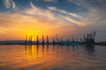 Colorful sunset over sea port and industrial cranes, Varna, Bulgariaの写真素材