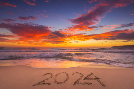 Happy New Year 2024 concept, lettering on the beach. Written text on the sea beach at sunrise.の写真素材