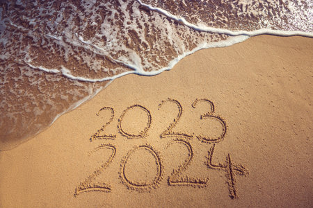 Happy New Year 2024 concept, lettering on the beach. Written text on the sea beach at sunrise.の写真素材
