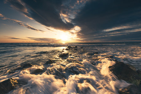Golden splashing waves and sunrise seaの写真素材