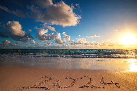Happy New Year 2024 concept, lettering on the beach. Written text on the sea beach at sunrise.の写真素材