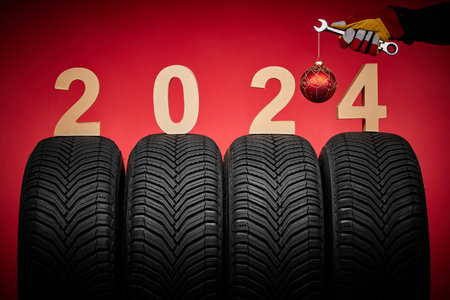 Winter car tires, hand of mechanic man with christmas ball, 2024 backgroundの写真素材