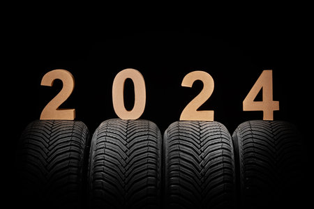 Car tires, winter wheels and text new year 2024 isolated on black backgroundの写真素材