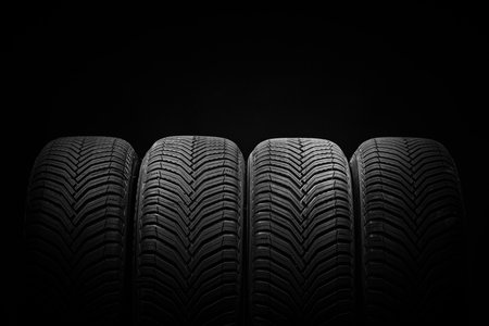Car tires, winter wheels isolated on black backgroundの写真素材