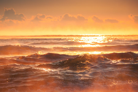 Close up of waves on the beach and a beautiful sunrise over the sea