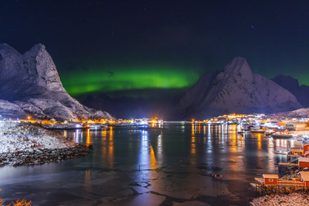 Aurora borealis northern lights over Lofoten Islands, Reine, Hamnoy, Norway, sea rocky shore and...