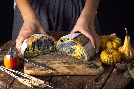 Homemade crusty sourdough bread oven baked and woman baker with autumn foods in kitchen