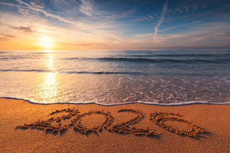Happy New Year 2026 concept, lettering on the beach. Written text on the sea beach at sunrise.