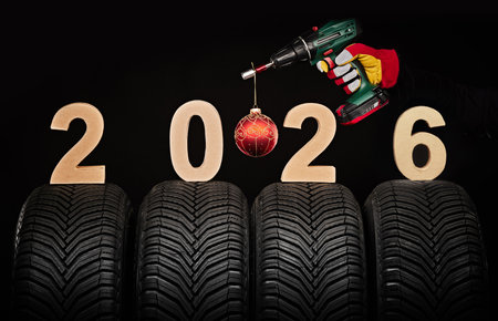 Winter car tires, big wheels service and hand of mechanic man with wrench and christmas ball, new...