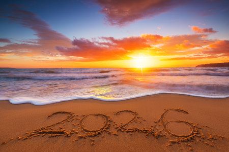 Happy New Year 2026 concept, lettering on the beach. Written text on the sea beach at sunrise.