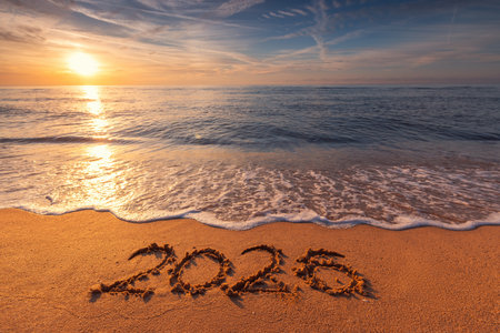 Happy New Year concept, lettering on the beach. Written text on the sea beach at sunrise.の写真素材