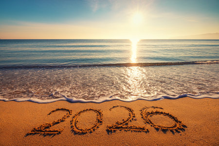 Happy New Year concept, lettering on the beach. Written text on the sea beach at sunrise.