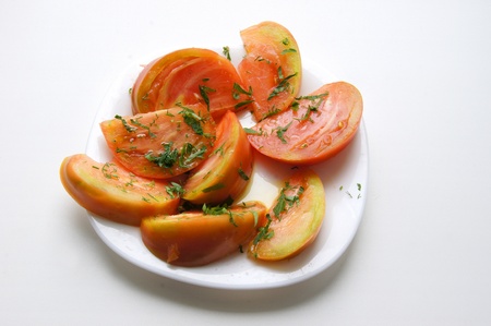 Tomato, sliced on a white plateの写真素材