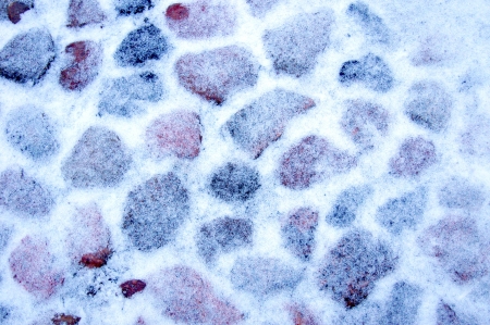 Background in the form of cobblestone road covered with snowの写真素材