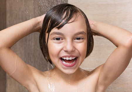 Smiling beautiful girl bathing under a shower at homeの写真素材