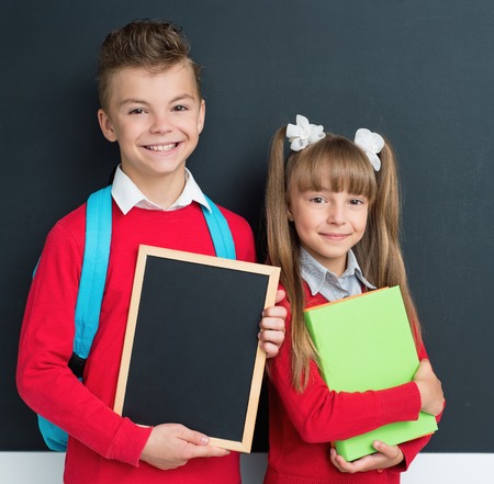 Happy pupils posing together in front of a big chalkboardの写真素材