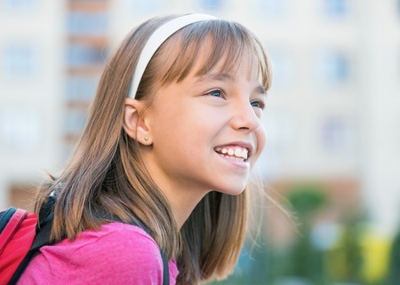 Close-up portrait of smiling girl with schoolbag. Back to school concept.の写真素材