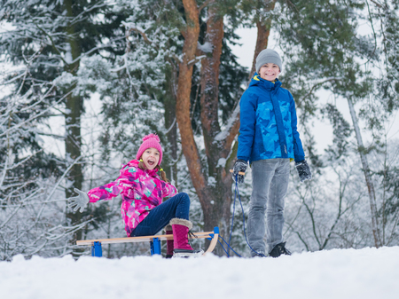 Child play in snow with sled