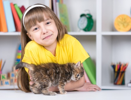 Little girl with kitten at homeの写真素材
