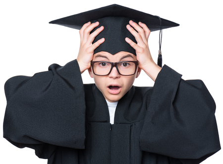 Portrait of a sad or surprised graduate teen boy student in mantle with black hat and eyeglasses, isolated on white backgroundの写真素材