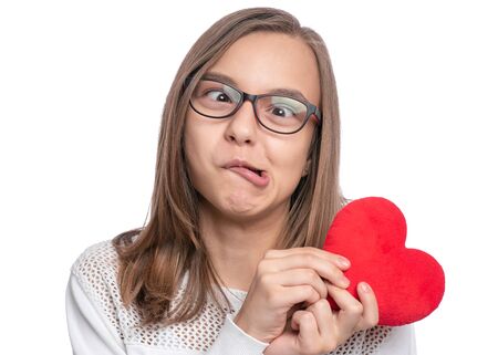 Happy Valentines Day with Love. Cute young Teen Girl in Eyeglasses with Red plush Heart making...