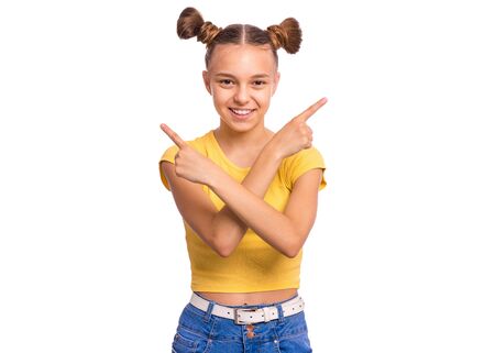 Portrait of teen girl crosses hands over chest and pointing index fingers in different sides or directions, cant make choice. Child pointing fingers. Beautiful teenager, isolated on white background.の写真素材