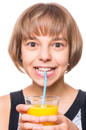 Beautiful caucasian little girl drinking fresh orange juice. Emotional portrait of attractive happy child with glass, isolated on white background.の写真素材