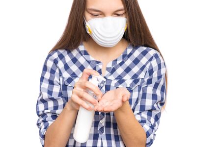 Concept of coronavirus quarantine. Child wearing medical protective mask applying an antibacterial antiseptic soap for hands disinfection and health protection during flu virus outbreak. COVID-19.の写真素材