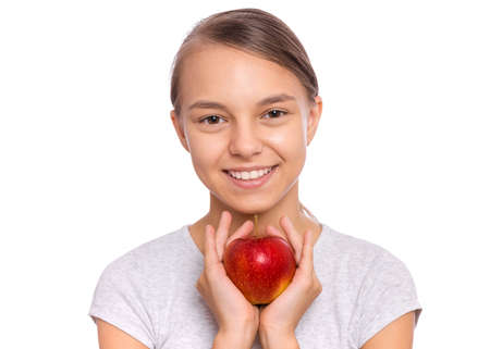 Happy beautiful young teen girl holds apple, isolated on white backgroundの写真素材
