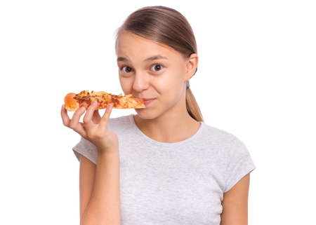 Happy beautiful young teen girl holds slice of pizza, isolated on white backgroundの写真素材