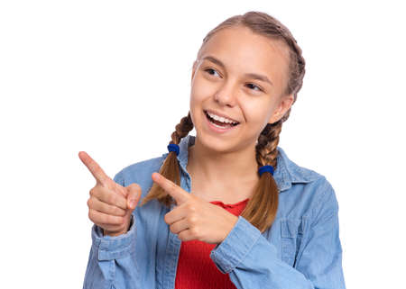 Happy teenage girl pointing up, gesturing idea or doing number one gesture, isolated on white backgroundの写真素材