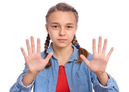 Beautiful teenage girl shows with hands a stop sign on an isolated backgroundの写真素材