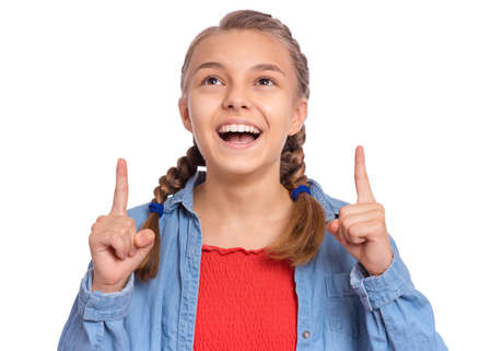 Happy teenage girl pointing up, gesturing idea or doing number one gesture, isolated on white backgroundの写真素材
