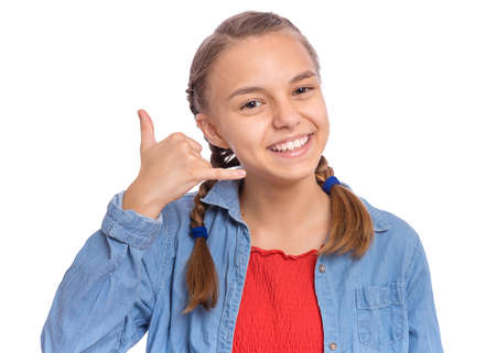 Smiling teenage girl with phone shaped hand, isolated on white backgroundの写真素材