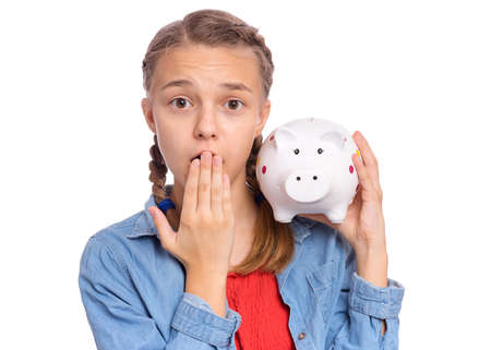 Beautiful teenage girl holds a piggy bank in her hands, isolated on white backgroundの写真素材