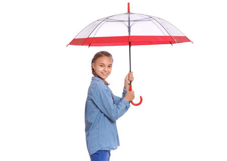 Beautiful teenage girl holding umbrella in hands, isolated on white backgroundの写真素材