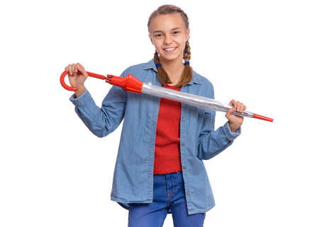 Beautiful teenage girl holding umbrella in hands, isolated on white backgroundの写真素材