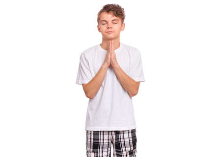 Handsome teen boy with hands folded in prayer hoping for better, isolated on white backgroundの写真素材