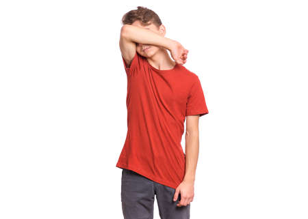 Handsome teen boy with sad expression covering face with hands while crying, isolated on white backgroundの写真素材
