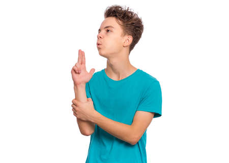 Handsome teen boy pointing hand and fingers to head like gun, suicide gesture, isolated on white backgroundの写真素材