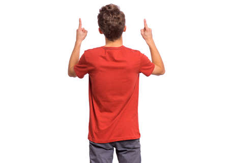 Handsome teen boy with his back turned to camera, pointing to something, isolated on white backgroundの写真素材