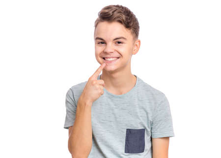 Handsome teen boy showing his to teeth, isolated on white backgroundの写真素材