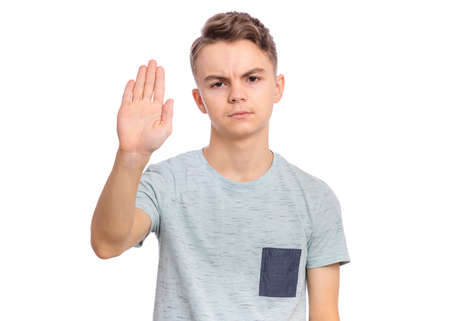 Handsome teen boy showing stop gesture with his palm, isolated on white backgroundの写真素材
