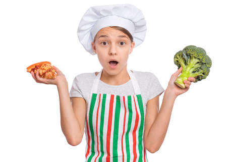 Girl wearing a chefs hat with emotions holding groceries in hands, isolated on white background.の写真素材