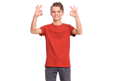 Handsome teen boy laughing looking very happy, isolated on white background.の写真素材