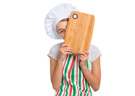 Cute girl in chef uniform isolated on white background showing menu blackboardの写真素材